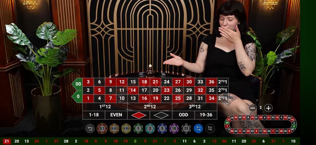 A live dealer standing at a roulette table in a streamed casino studio