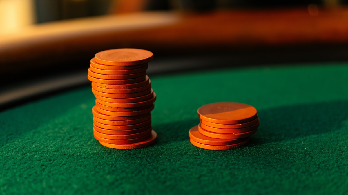 A tall stack and a three-chip stack side by side on casino baize