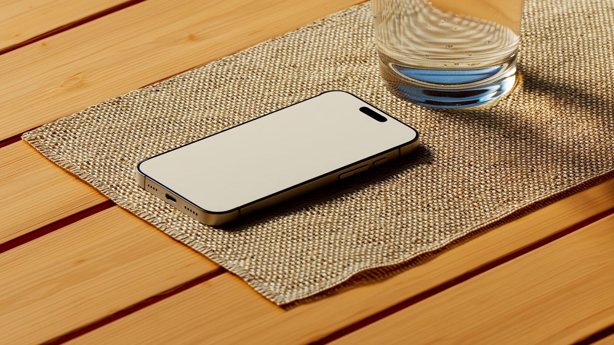 A phone lying face-down on a woven placemat beside a glass of water